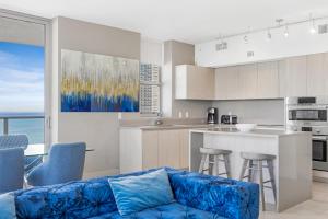 a living room with a blue couch in a kitchen at HYDE BEACH HOUSE RESORT #2101 - MILLION APARTMENT 2BD/2BA. DIRECT OCEAN VIEW. 1 MIN FROM BEACH. 6 GUESTS. in Hollywood