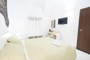 a white bedroom with a bed and a desk at Be happy Rooms in Catania