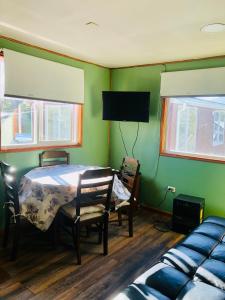 a bedroom with a bed and a table and chairs at Departamento Eusebio Lillo in Coihaique