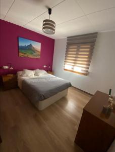 特倫普的住宿－Sant Jordi 2，一间卧室配有一张床和紫色的墙壁