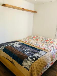 Una cama con edredón en una habitación en Departamento Eusebio Lillo, en Coyhaique