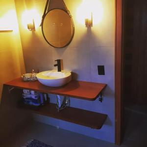 a bathroom with a sink and a mirror on a counter at Chalé dos Canyons Rio do Rastro in Bom Jardim da Serra