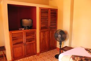 a bedroom with a fan and a room with a television at Hotel Casa San Francisco in Granada