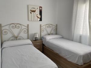 a bedroom with two beds with white sheets and a mirror at Entre montañas in Árchez +41 photos