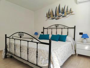 a bedroom with a bed with two sailboats on the wall at Villa Su Giudeu in Chia