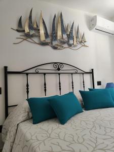 a bedroom with a large bed with blue pillows at Villa Su Giudeu in Chia