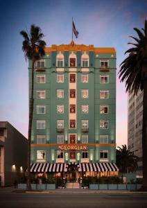 a green building with a flag on top of it at The Georgian Hotel in Los Angeles