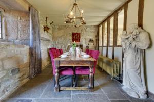 een eetkamer met een tafel met roze stoelen bij Derbyshire Chapel for 6 at Harthill Hall private hot tub 8am - 10pm plus private daily use of indoor pool and sauna 1 hour in Stanton in Peak
