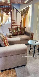 een woonkamer met 2 banken en een tafel bij Odyssey Suites Loft Apartment in Georgetown