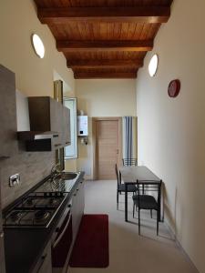 cocina con fogones y mesa con sillas en IN CENTRO Rooms and Apartments en Isola del Liri