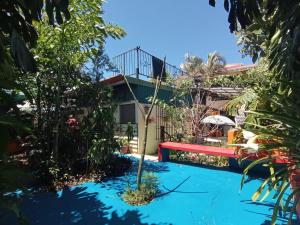 a house with a swimming pool with a red bench at Nirvana Apartament Hostal in Alajuela