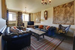 a living room with a leather couch and a table at Derbyshire Chapel for 6 at Harthill Hall private hot tub 8am - 10pm plus private daily use of indoor pool and sauna 1 hour in Stanton in Peak