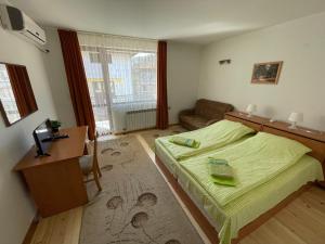 a bedroom with a bed and a desk and a couch at Family Hotel Biju in Tryavna