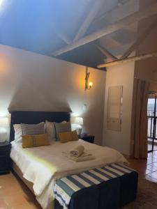 1 dormitorio con 1 cama grande y techo azul en Matori Lodge, en Modimolle