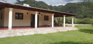 uma pequena casa com um alpendre e um quintal relvado em La Soñada de La Majadita em San Agustín de Valle Fértil
