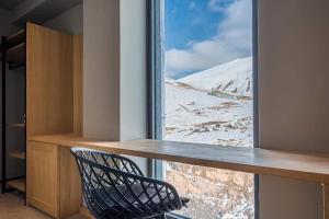 a room with a window with a desk and a chair at New Gudauri Atrium in Gudauri