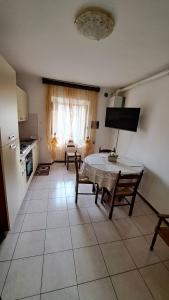 a living room with a table and a kitchen at La Casetta di Zia Palmina in Recanati