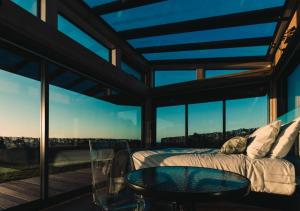 a bedroom with a bed and a glass table at Kokomea PurePod in Te Horo