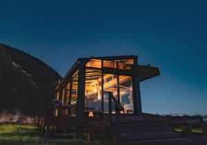 uma casa de vidro sentada em alguns degraus à noite em Kokomea PurePod em Te Horo
