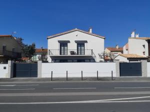 een wit huis met een hek en een straat bij Appartement fonctionnel proche du centre ville in Narbonne