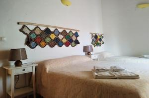 a bedroom with two beds and two tables with lamps at Monte da Choça in São Teotónio