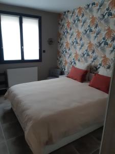 een slaapkamer met een groot wit bed met rode kussens bij Appartement fonctionnel proche du centre ville in Narbonne