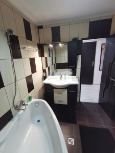 a bathroom with a bath tub and a sink at Apartament Kalinderu K3 Busteni in Buşteni +48 photos