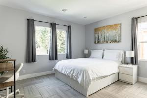 1 dormitorio con 1 cama blanca y 2 ventanas en Modern 6 Bedrooms Hollywood Urban Home, en Los Ángeles