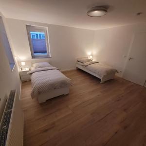 1 dormitorio con 2 camas y ventana en Apartments am Kochertal, en Oedheim