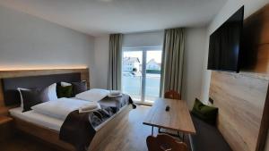 ein Schlafzimmer mit einem Bett und einem großen Fenster in der Unterkunft Hotel Gasthof Sonnenhang in Denkendorf
