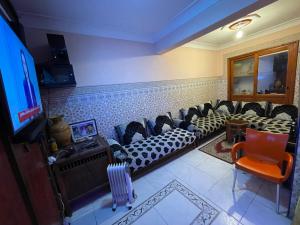 a living room with a couch and chairs and a tv at Dar Echorafa in Marrakesh