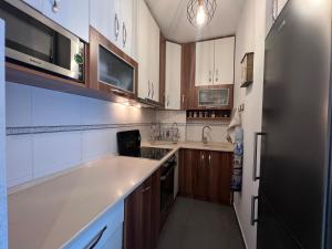 a kitchen with wooden cabinets and a stainless steel refrigerator at Lucky Apartments II in Pristina