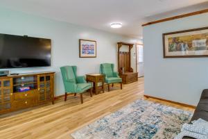een woonkamer met een flatscreen-tv en groene stoelen bij Cozy Mountain Home Studio 8 Mi to Bull Shoals Lake in Mountain Home