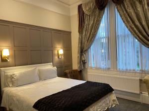 a bedroom with a bed and a large window at Pulteney House in Bath