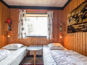 twee bedden in een kamer met een tafel en een raam bij Holiday home Fanø LXXIX in Fanø