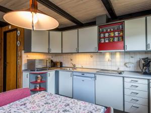 a kitchen with white cabinets and a table and a light at Holiday home Fanø LXXIX in Fanø