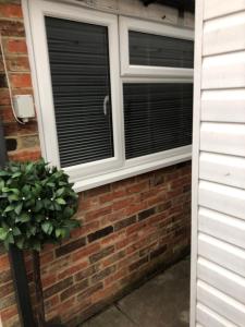 a window with blinds on a brick wall at The Annexe Bedford in Bedford