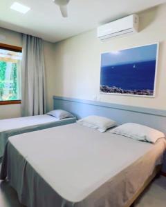 2 Betten in einem Zimmer mit Fenster in der Unterkunft Cumuru pé na areia in Cumuruxatiba