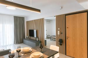 a living room with a dining table and a television at Valentinos Apartments in Kallithea Halkidikis
