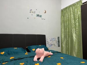 Un animal de peluche rosa de Hello Kitty acostado en una cama en Cozy homestay Manhattan Ipoh,12 pax 怡保民宿, en Ipoh