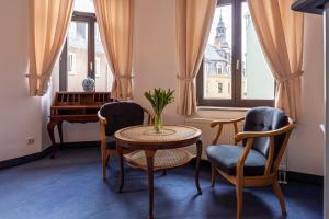 um quarto com uma mesa e cadeiras e um piano em Hotel Mauritius em Crimmitschau