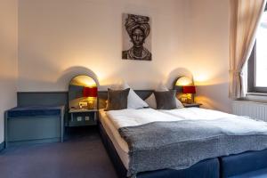 - une chambre avec un lit et une photo sur le mur dans l'établissement Hotel Mauritius, à Crimmitschau
