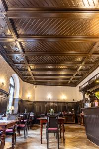 a restaurant with wooden ceilings and tables and chairs at Hotel Mauritius in Crimmitschau