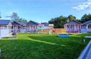 a large yard with a playground with houses at Pastelowe Borne in Borne Sulinowo