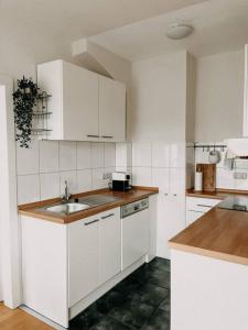 a kitchen with white cabinets and a sink at Ruhig, zentral, Messe nah! BE3L in Essen
