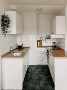 a white kitchen with white cabinets and a sink at Ruhig, zentral, Messe nah! BE3L in Essen