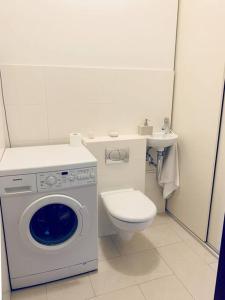 a bathroom with a washing machine and a toilet at Luxurious Holiday Apartment in Warsaw in Warsaw