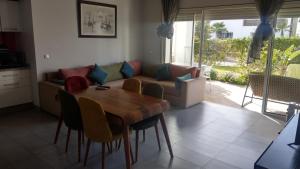 a living room with a table and a couch at Perla à 200 m de la plage in Saidia 