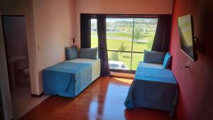 a room with two beds and a large window at Galeano Aparts in Santa Rosa