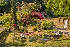 a park with benches and flowers in the grass at Villa Namaste - Cabaña Albores in Curití